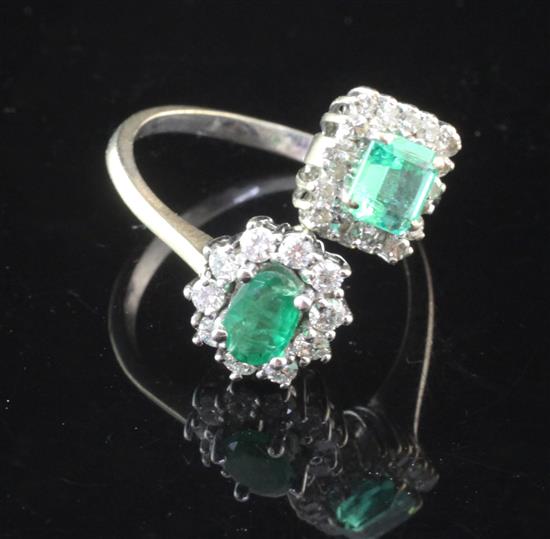 A white gold, emerald and diamond cluster crossover ring, size M.